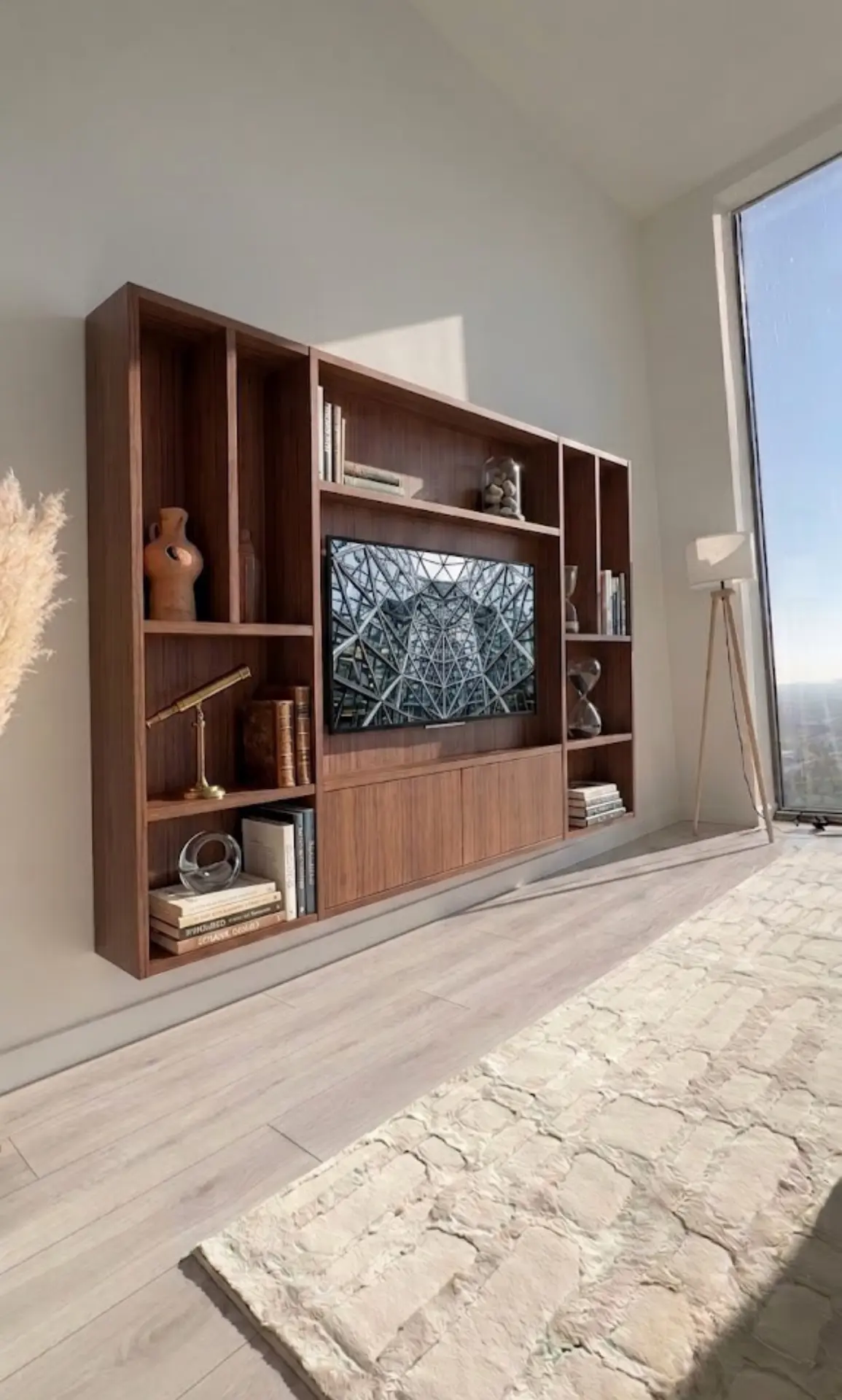 Houten cinewall met tv en decoratie in lichte woonkamer